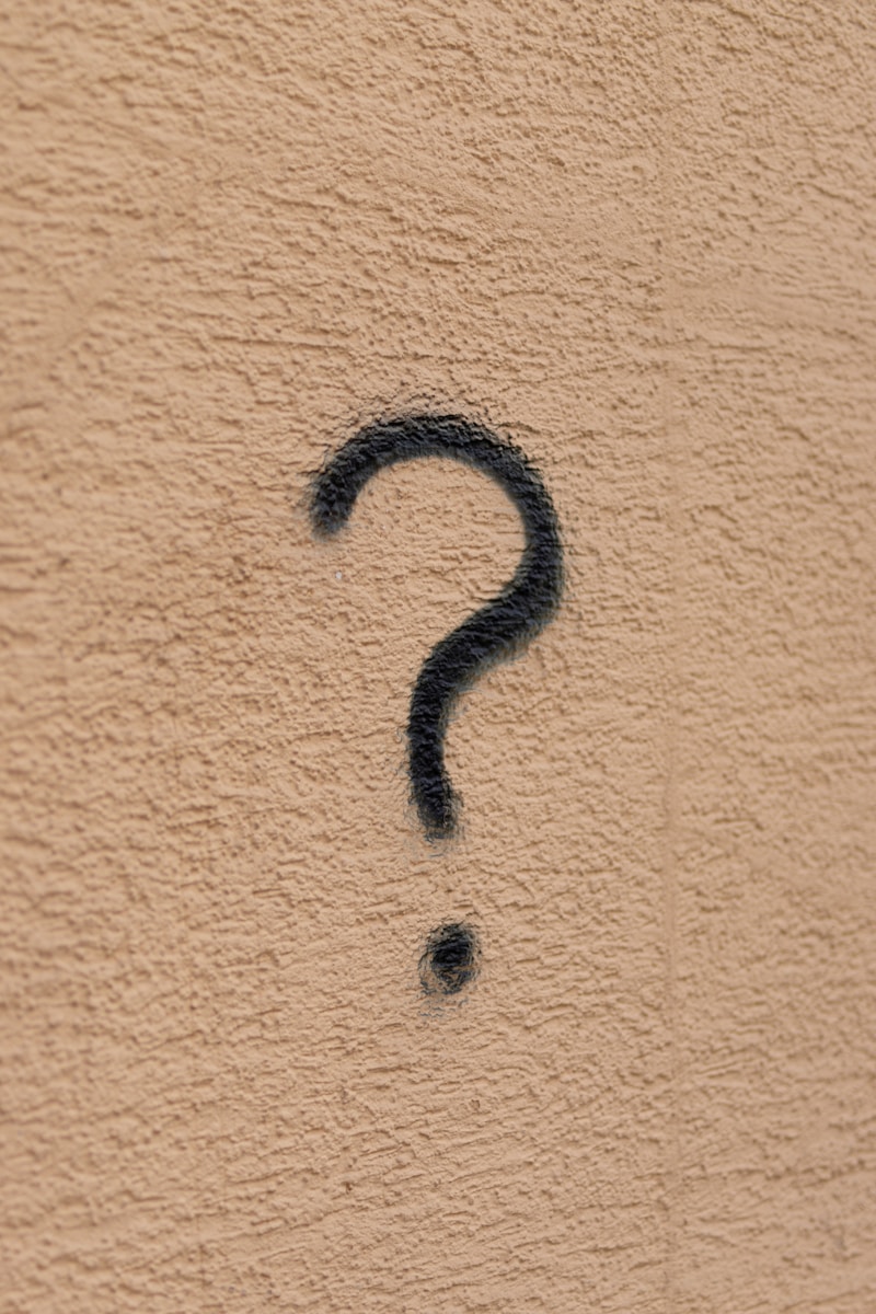 black metal wall mounted hook with a question mark symbolizing 12 questions you should ask your insurance agent